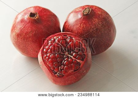 Big Ripe Red Granets Or Garnets. Fruits Of Red Ripe Pomegranate On The White Background. Vegetarian 