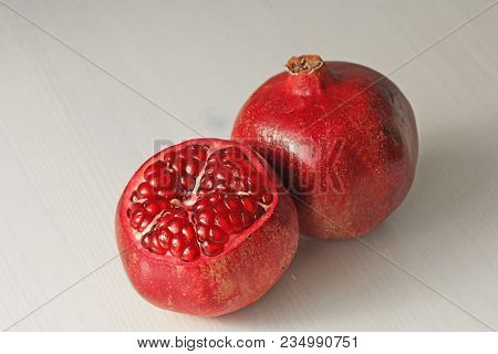 Big Ripe Red Granets Or Garnets. Fruits Of Red Ripe Pomegranate On The White Background. Vegetarian 