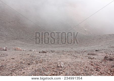The Etna Volcano. Black Volcanic Earth And Thick Fog On Mount Etna. Place For Text. The Island Of Si