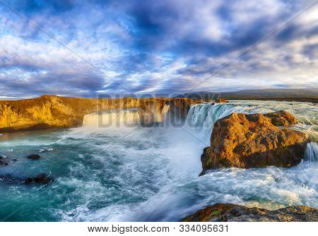 Breathtaking Sunset Landscape Scene Of Powerful Godafoss Waterfall. Dramatic Sky Over Godafoss. Loca