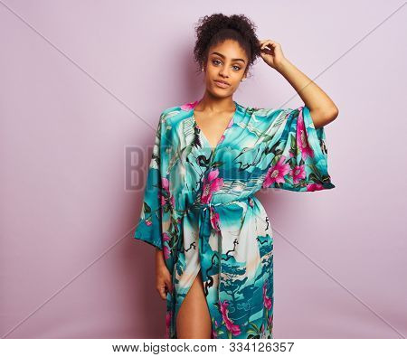 Young beautiful african american woman standing wearing elegant colorful caftan