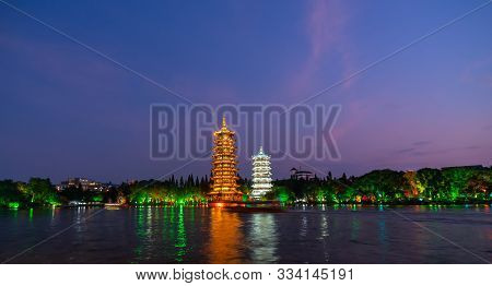 Sun And Moon Pagodas Towers At Shanhu Or Shan Lake In Guilin Town Illuminated By Colourful Lights At