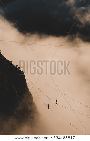 Two Highliners Are On A Line Above The Cloud. Highliner In The Mountains Above The Canyon. Tightrope