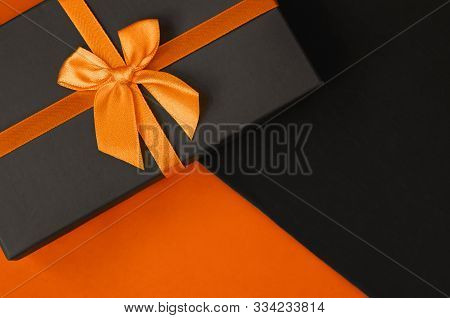 A Stylish Gift Box On Duotone Orange And Black Background With Copy Space. Present For Man With A Pe