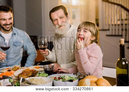 Multi Generation Family Sitting At The Table And Having Tasty Dinner, Celebrating Thanksgiving. Gran