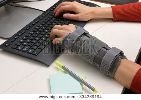 Contused Woman Hand In Stabilizer Working On Computer