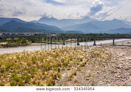 bridge over river with golden miscanthus under sky