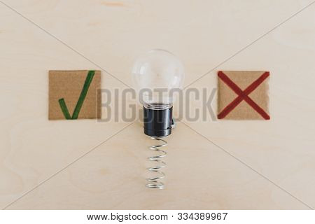 Feedback About Good And Bad Ideas, Lightbulb On Spring With Green Tick And Red Cross