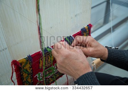 Weaving And Manufacturing Of Handmade Carpets Closeup. Womens Hands Weave A Carpet . Woman Hands Wea