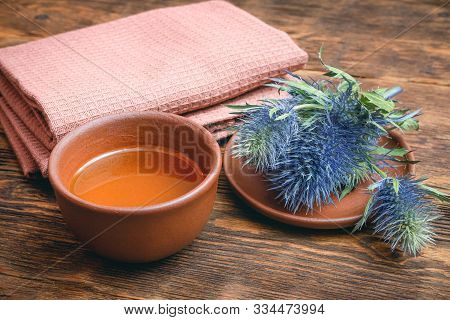 Feverweed Eryngium Plant Essential Oil And Fruits On Wooden Table. Herbal Medicine.