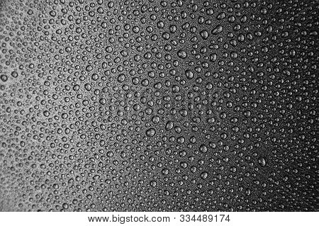 Abstract Background: Many Drops Of Water On A Dark Surface - Non-stick Coating In A Pan. Center In S