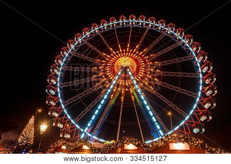 Illuminated Ferris Wheel and decorated market stalls at Christmas market (Christkindlmarkt) in Central Berlin, Germany
