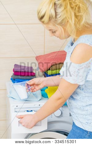 Washing Powder Detergent And Measuring Cup Pouring Into Machine. Household Duties, Clothes Laundry O