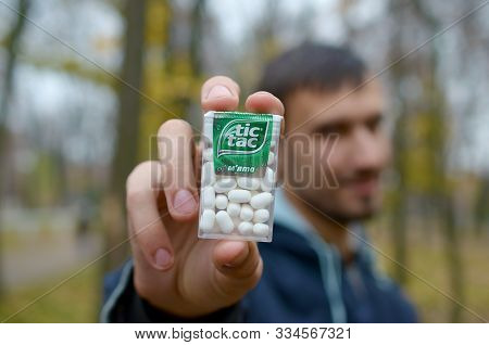 Kharkov, Ukraine - October 26, 2019: Young Man Shows New Tic Tac Hard Mints Package In Autumn Park. 