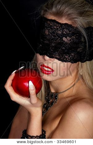 Bella donna con pizzo nero mangiare mela rossa isolato su sfondo nero
