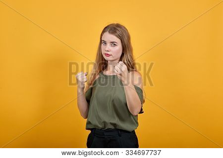 Young Beautiful Blonde Woman Wearing Pastel Haki Shirt Looks Happy And Excited Doing Fighting Gestur