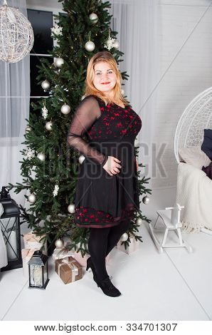 Lush, Beautiful, Young Woman Near Christmas Tree With Gifts