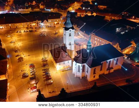 Aerial night shot of the church of St. Nicholas in Dobrany near Pilsen. Baroque monument on town main square. Western Bohemia, Czech Republic. European landmarks from above.