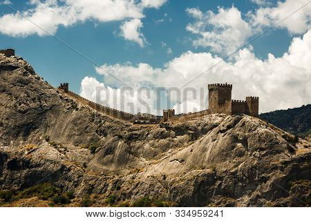 Sudak, Russia, 29 July, 2017. The wall of the Genoese fortress on the mountain Sudak Crimea. The wall on top of the mountain protects the city. The towers on top for the defense of the city.