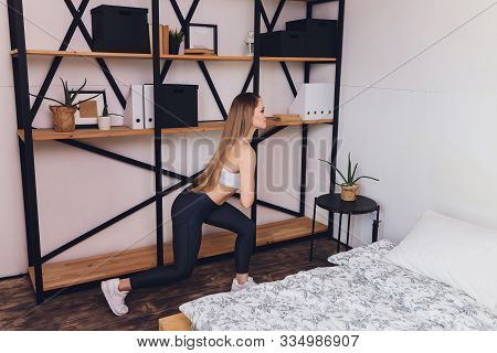 Attrctive Fitness Woman Doing Stretching Exercises At Home, As Part Of A Healthy Lifestyle Without G