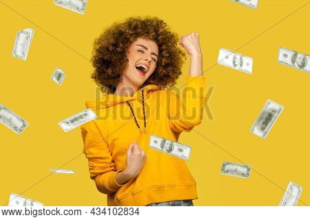 Money Rain. Yes I Did It. Portrait Of Joyous Winner Rich Young Woman In Yellow Hoody Standing Scream