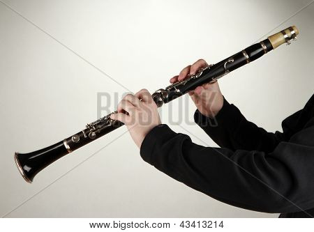Musiker spielen auf Klarinette auf grauem Hintergrund