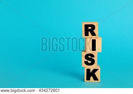Word Risk Made Of Wooden Cubes On Turquoise Background, Space For Text