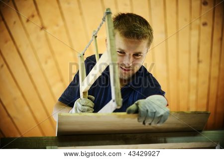 Carpintero trabajando por un lado vio cortar una espiga en cajones en su taller