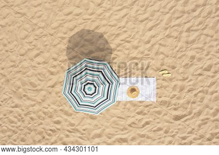 Beach Umbrella Near Towel And Other Vacationist's Stuff On Sand, Aerial View