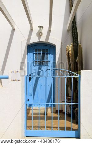 Typical Andalusian Whitewashed Facade With Blue Painted Window And Bench