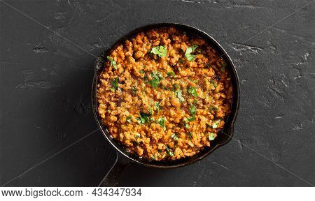 Close Up View Of Keema Curry In Frying Pan Over Black Stone Background. Indian And Pakistani Style D