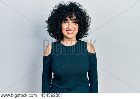 Young middle east woman wearing casual clothes with a happy and cool smile on face. lucky person. 