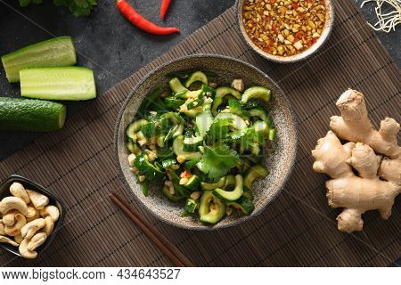Asian Spicy Broken Cucumbers Salad With Cilantro, Ginger, Pepper Chili, Black Vinegar On Black Backg