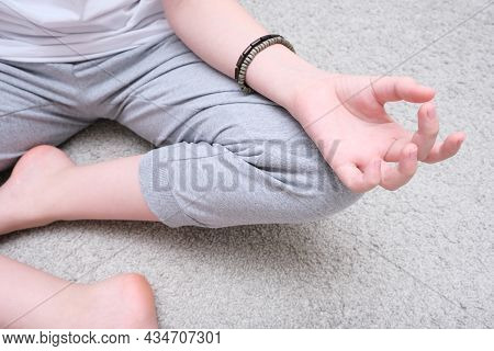 Unrecognizable Meditating Teenage Boy Sitting On A Carpet At Home, Spiritual Yoga Buddhism Practics,