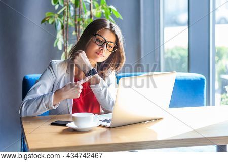 Time Is Gone. Portrait Of Serious Young Woman In Glasses Sitting, Looking At Laptop Screen On Video 