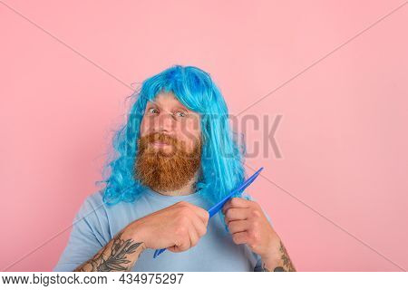 Happy Man With Beard And Blue Peruke Combs Her Hair Like A Woman
