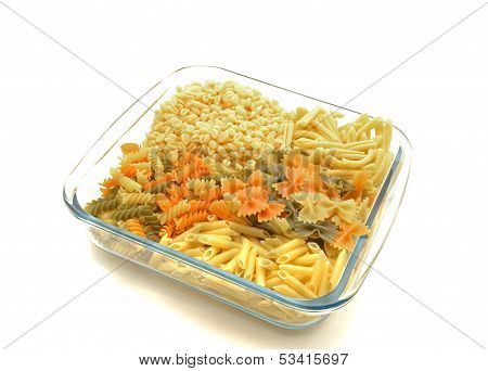 Glass bowl with four types of colored pasta