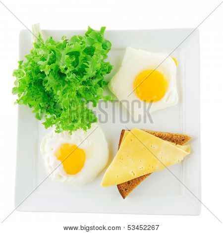 green lettuce salad and fried eggs on white
