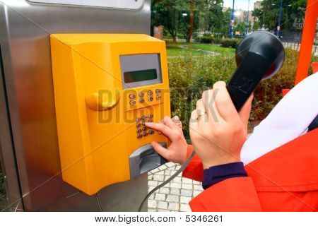 Woman Is Using The Public Telephone