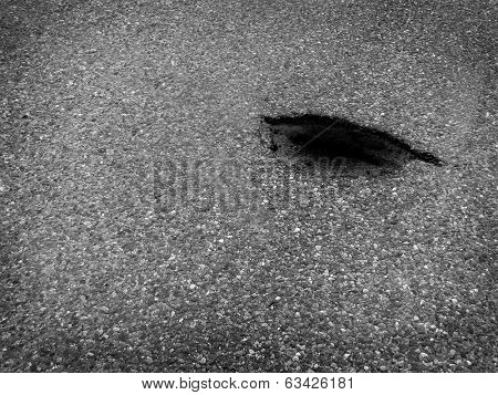Detail of pothole pot hole in roadway concrete asphalt