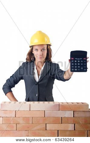Woman construction worker with calculator on white