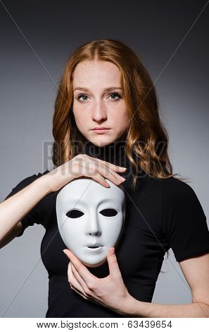 Redhead woman iwith mask in hypocrisy consept against black  background