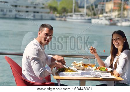 happy young couple having lanch at beautiful restaurant on by the sea on  beach