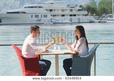 happy young couple having lanch at beautiful restaurant on by the sea on  beach