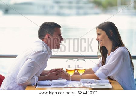 happy young couple having lanch at beautiful restaurant on by the sea on  beach