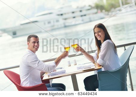 happy young couple having lanch at beautiful restaurant on by the sea on  beach