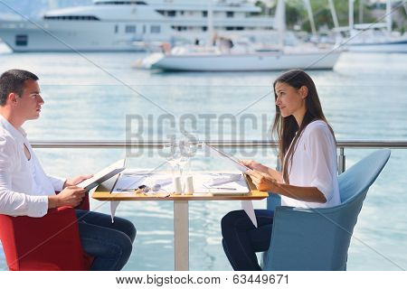 happy young couple having lanch at beautiful restaurant on by the sea on  beach