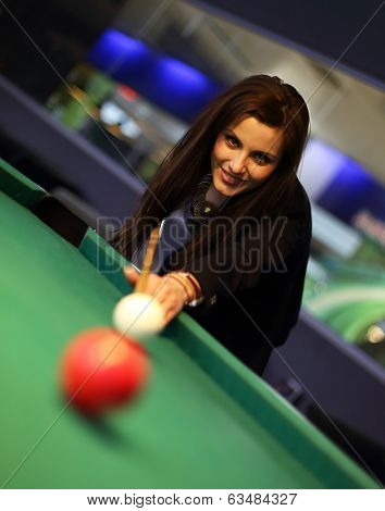 Young brunette girl playing snooker