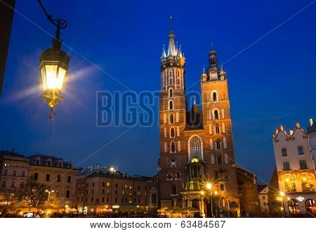 KRAKOW, POLAND - APR 7, 2014: St. Mary's Church on Rynek Glowny (Market Square) in night time. Rynek Glowny - roughly 40,000 m2 is largest medieval town square in Europe.