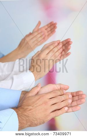 Clapping hands on bright background